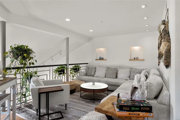 a living room with a sink and a mirror with wooden floor