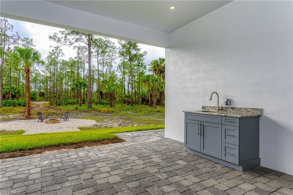 98 9th Street Southwest Naples, FL 34117 - Photo 27 of 27 Large lanai with outdoor cabinets and sink for a summer kitchen