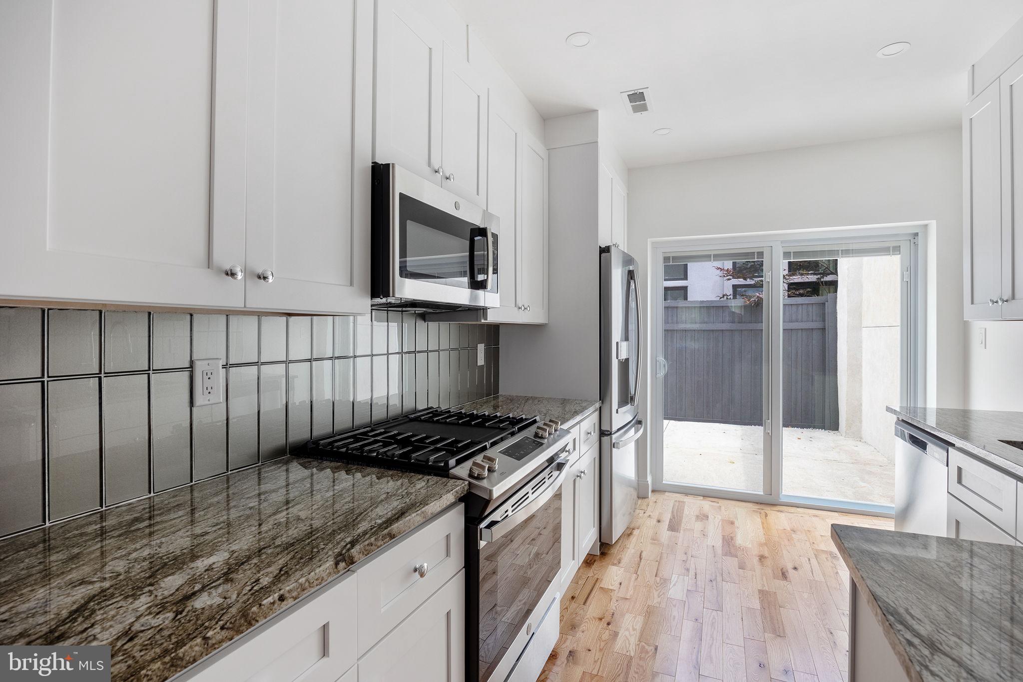 811 Kimball Street Philadelphia, PA 19147 - Photo 14 of 37 a kitchen with stainless steel appliances granite countertop a stove a sink and a microwave