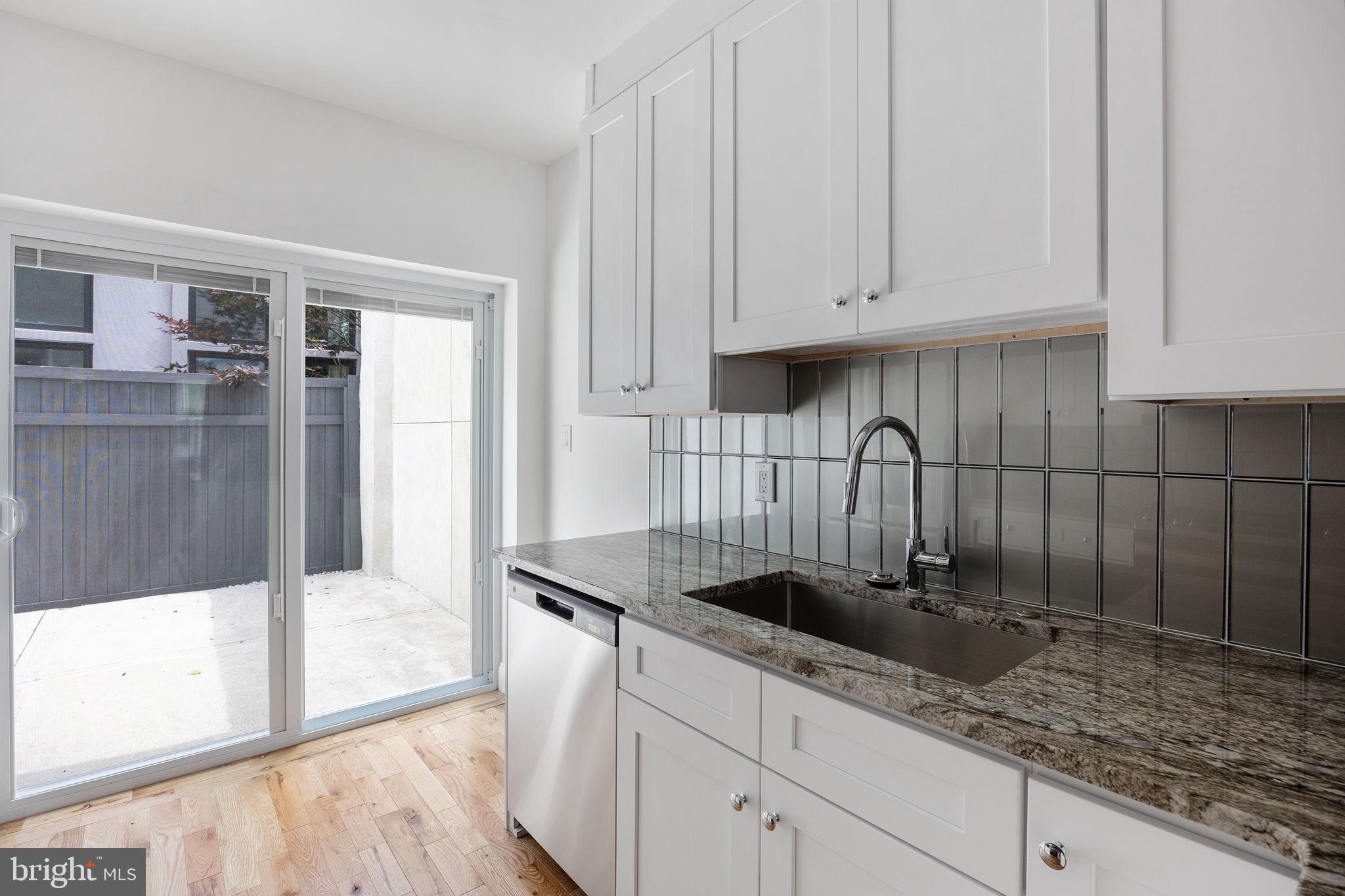 811 Kimball Street Philadelphia, PA 19147 - Photo 15 of 37 a kitchen with granite countertop a sink a stove and cabinets