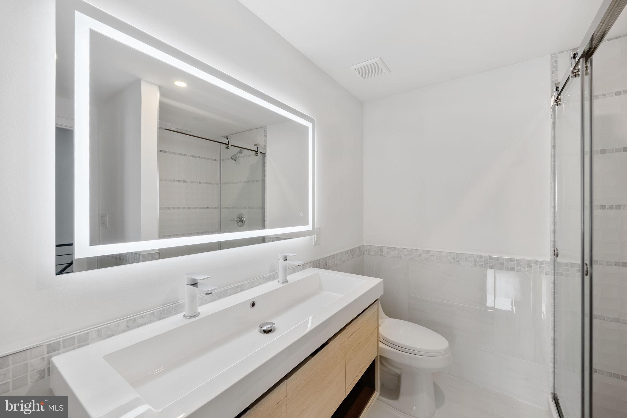 811 Kimball Street Philadelphia, PA 19147 - Photo 31 of 37 a bathroom with a sink mirror vanity and toilet
