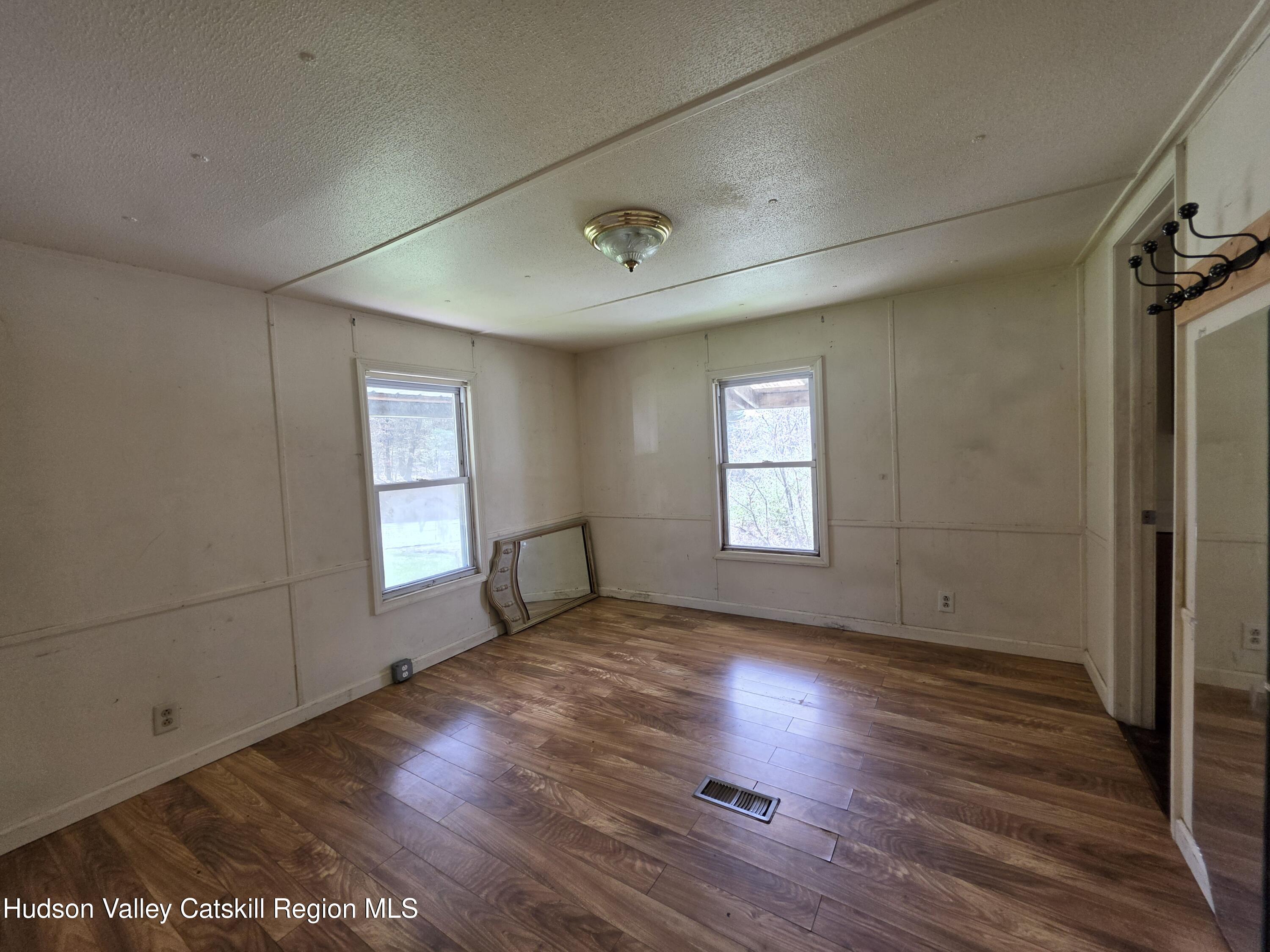 852 State Rt 17B Monticello, NY 12701 - Photo 11 of 26 a view of empty room with wooden floor and fan