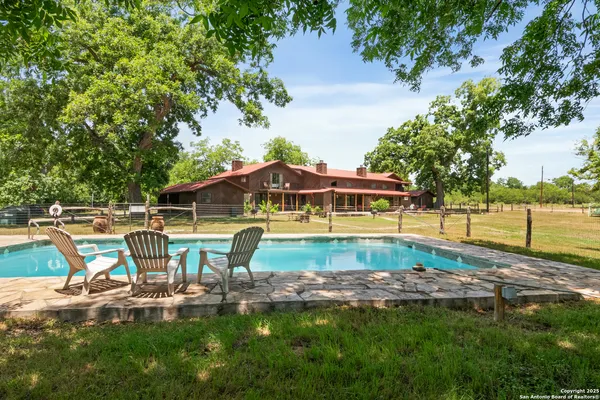 a view of a house with pool and sitting area