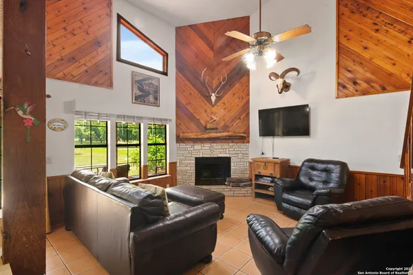a living room with furniture a fireplace and a flat screen tv