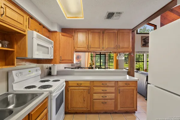 a kitchen with granite countertop a sink and a refrigerator