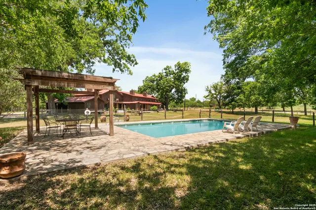 a view of a swimming pool with a bench and trees around