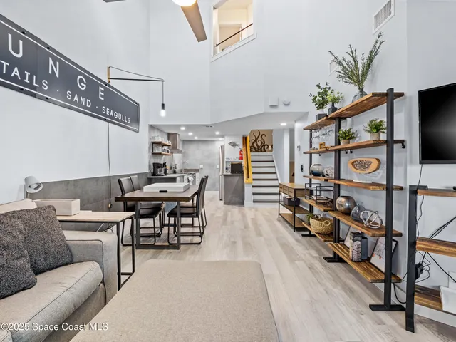 a living room with furniture a flat screen tv and a table