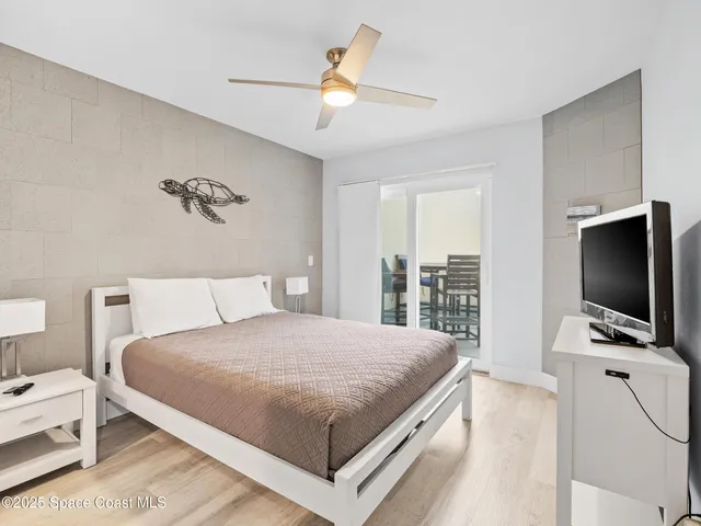 a bedroom with a bed and a flat tv screen on dresser