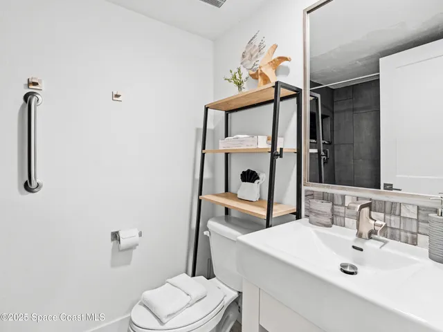 a bathroom with a sink mirror vanity and toilet