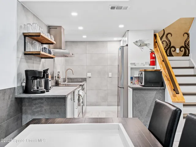 a kitchen with stainless steel appliances granite countertop a refrigerator and a stove top oven
