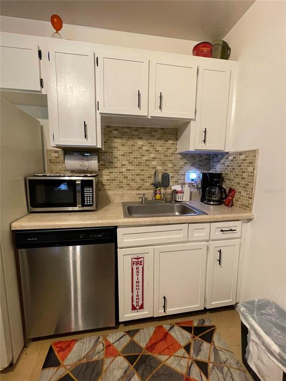 239 South McMullen Booth Road, Unit 38 Clearwater, FL 33759 - Photo 16 of 32 a kitchen with stainless steel appliances granite countertop a stove and white cabinets