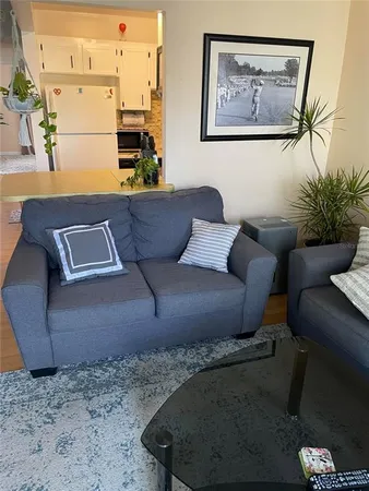 a living room with furniture and a painting on the wall