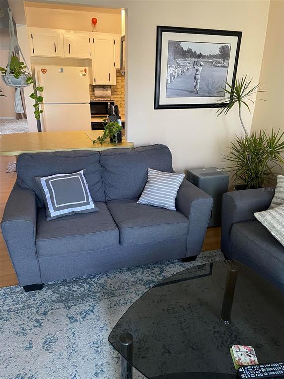 239 South McMullen Booth Road, Unit 38 Clearwater, FL 33759 - Photo 9 of 32 a living room with furniture and a painting on the wall