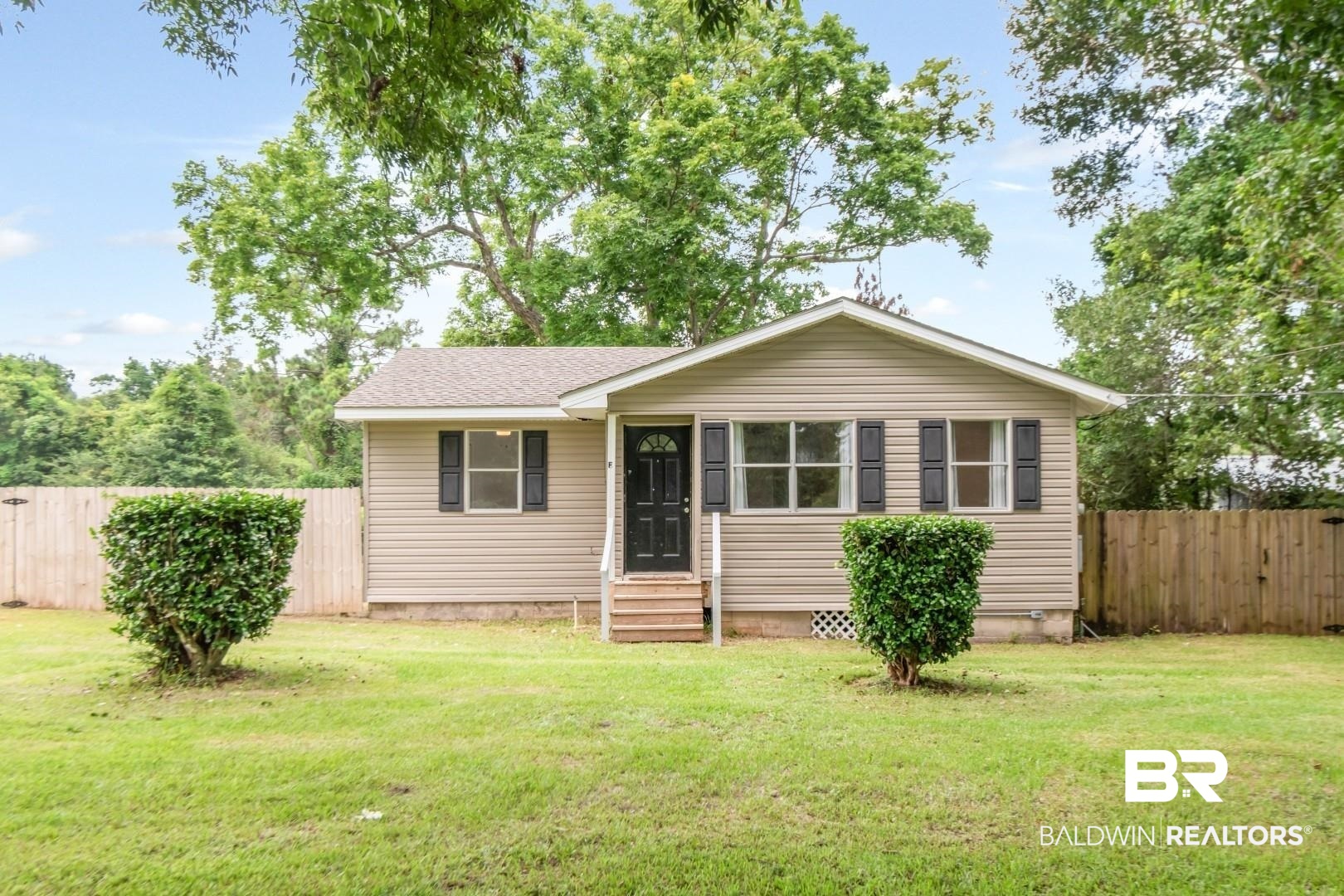 2905A McFarland Road, Unit F Mobile, AL 36695 - Photo 1 of 29 Single-story residence featuring light-colored siding, a dark front door with decorative glass, white trim, and dark window shutters
