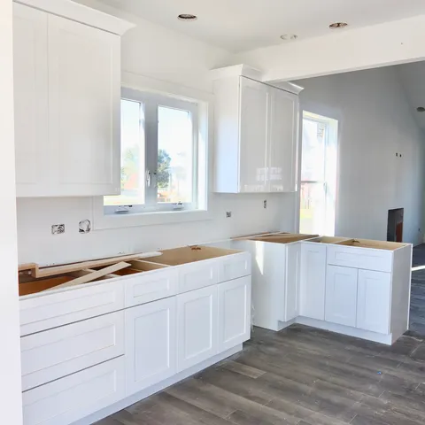 a kitchen with granite countertop white cabinets and white appliances