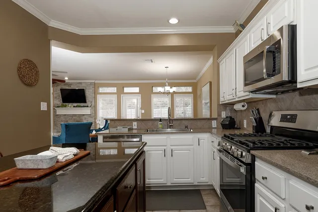 a kitchen with stainless steel appliances a stove microwave sink refrigerator and cabinets