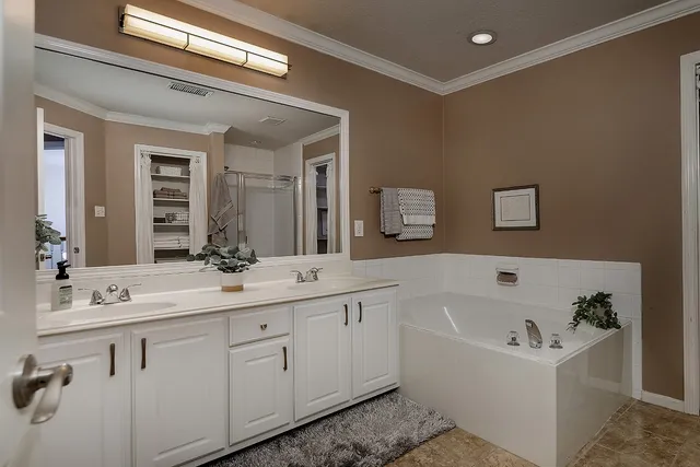 a bathroom with a bathtub a mirror a sink and vanity