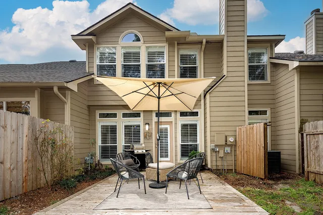 a view of a house with a chairs and table in a patio