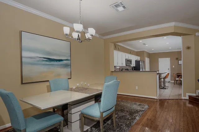a view of a dining room with furniture a chandelier and wooden floor