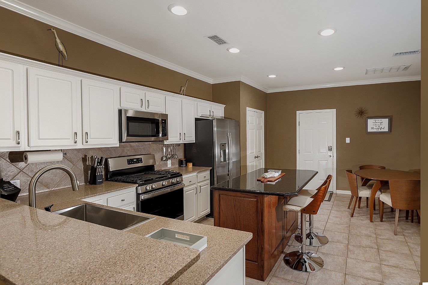 110 North Valley Oaks Circle The Woodlands, TX 77382 - Photo 9 of 29 a kitchen with stainless steel appliances kitchen island granite countertop a sink and cabinets