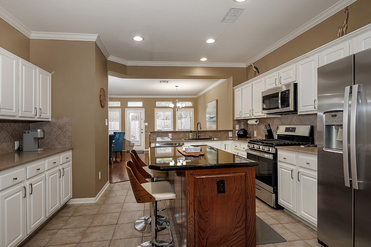 110 North Valley Oaks Circle The Woodlands, TX 77382 - Photo 10 of 29 a kitchen with stainless steel appliances granite countertop a stove top oven a sink dishwasher a refrigerator and white cabinets with wooden floor