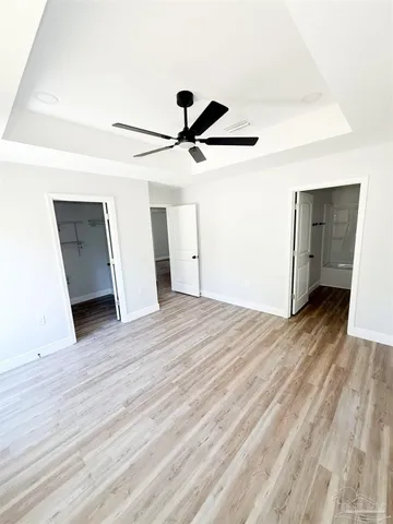 a view of a livingroom with wooden floor and a ceiling fan