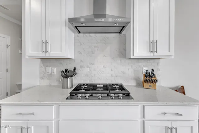 a living room with stainless steel appliances granite countertop furniture wooden floor and a chandelier