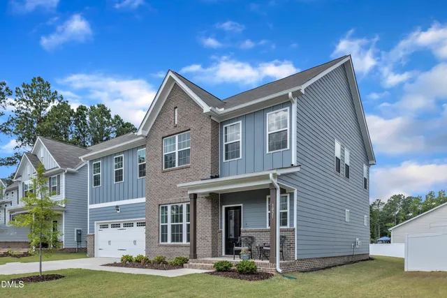 a front view of a house with a garden and plants