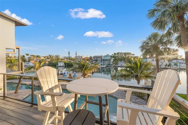 a view of a balcony with dining table and chairs with wooden floor