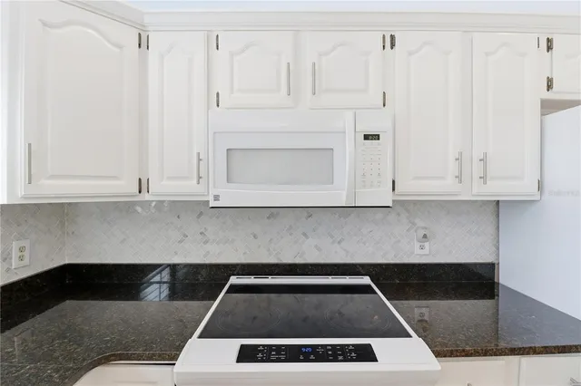a kitchen with white cabinets and a stove