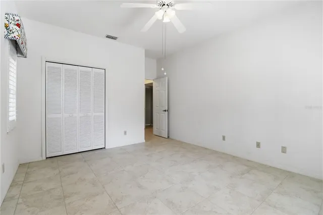 an empty room with a ceiling fan and entryway