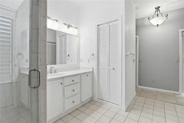 a spacious bathroom with a double vanity sink a mirror and a shower