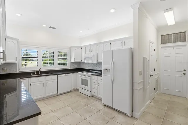 a kitchen with stainless steel appliances granite countertop a refrigerator and a sink
