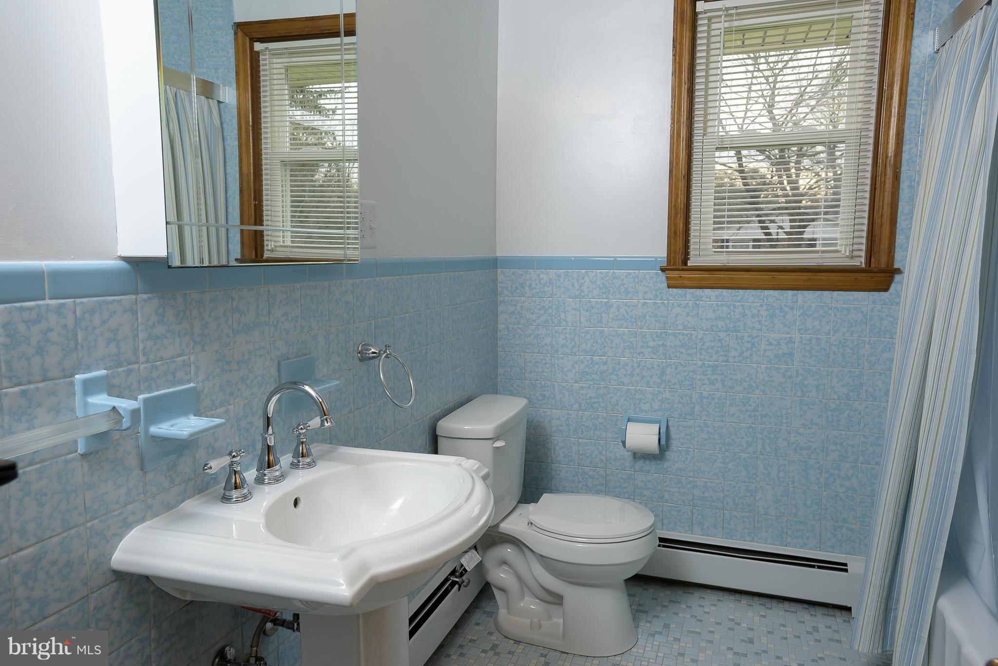 871 Elmhurst Road Severn, MD 21144 - Photo 14 of 28 a bathroom with a toilet a sink and mirror