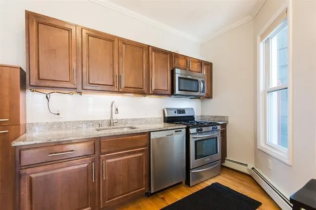 a kitchen with stainless steel appliances granite countertop a stove a sink and a microwave