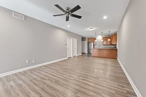 a view of empty room with wooden floor and window