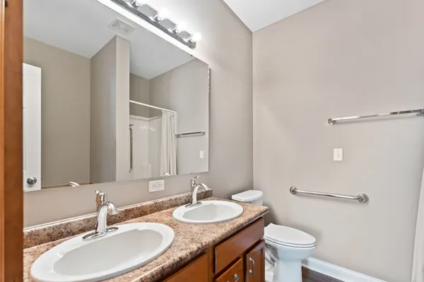 a bathroom with a granite countertop sink a toilet and a mirror