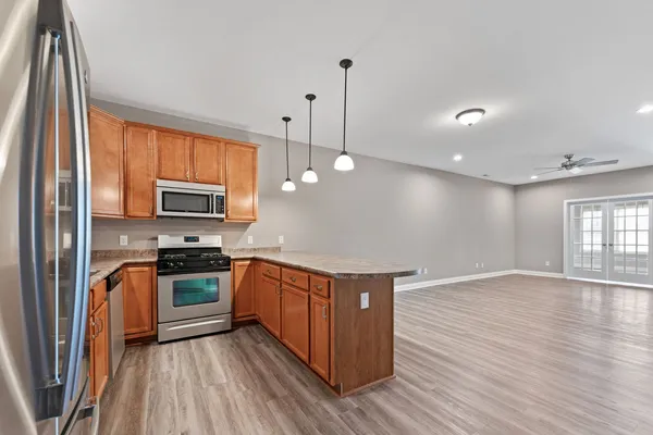 a kitchen with stainless steel appliances granite countertop a sink a stove and a wooden floors