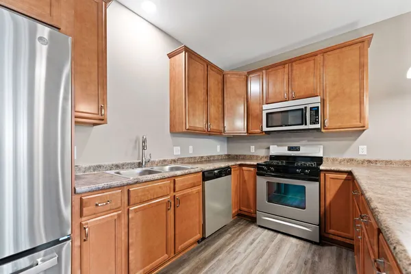 a kitchen with stainless steel appliances granite countertop a stove a sink and a microwave