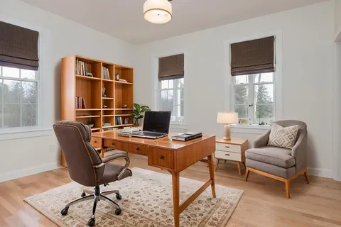 a view of a workspace with furniture and a window
