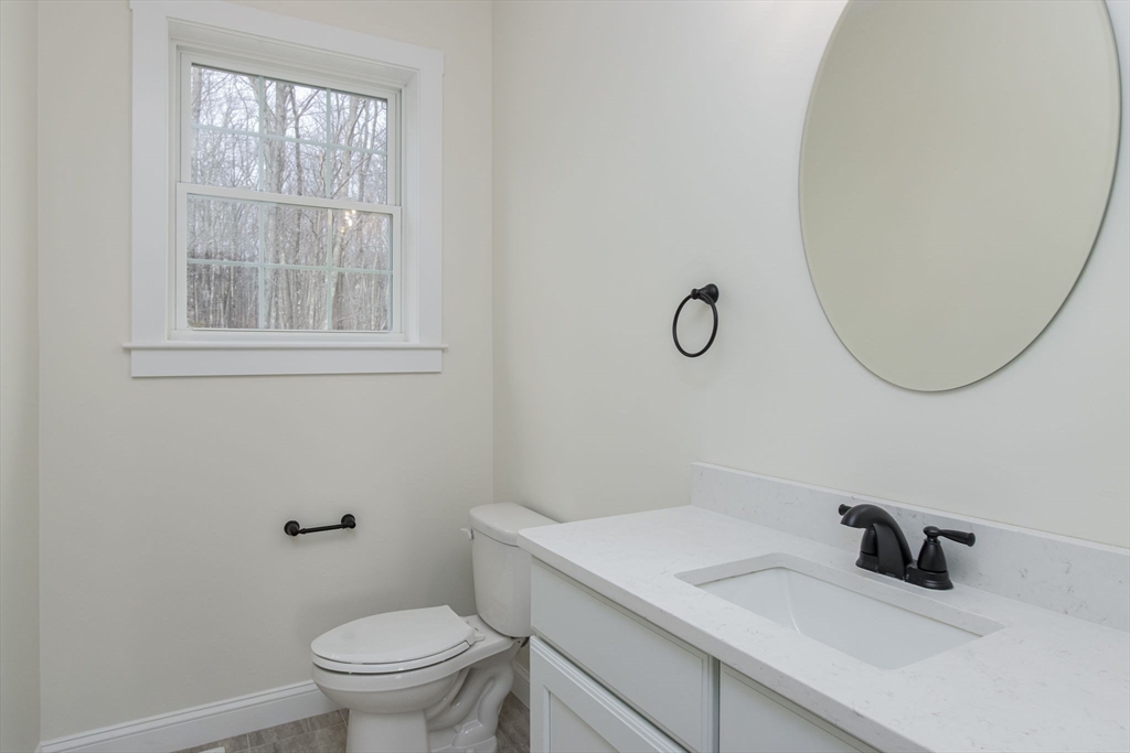 76 Robin Hill Road Groton, MA 01450 - Photo 15 of 42 a bathroom with a granite countertop sink a toilet and a mirror