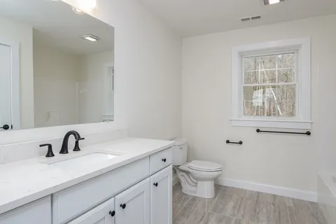 a bathroom with a sink toilet a mirror and shower