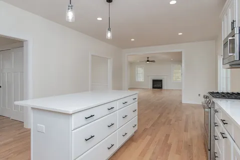 a kitchen with stainless steel appliances kitchen island granite countertop a stove a sink and a refrigerator