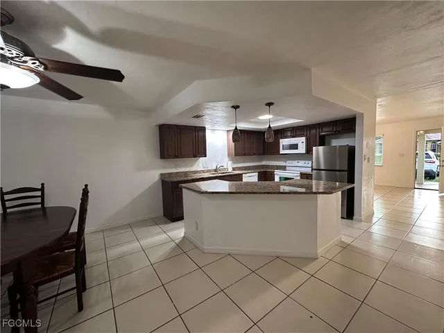 a kitchen with stainless steel appliances kitchen island granite countertop a sink and a stove