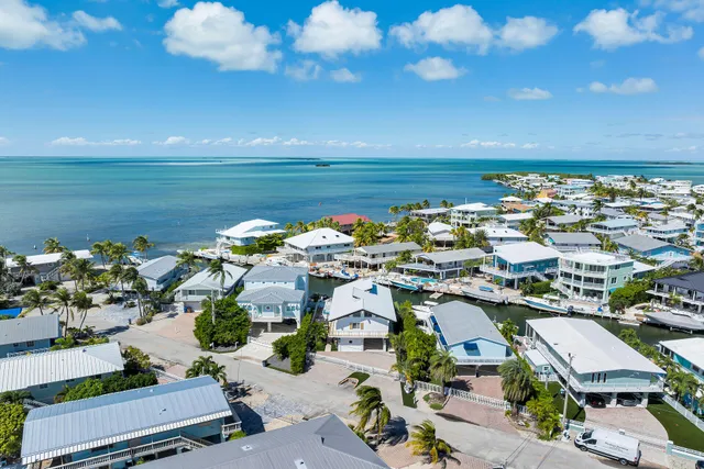 an aerial view of a house with swimming pool and outdoor seating
