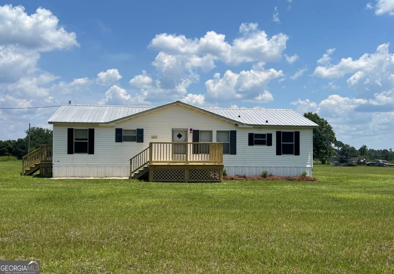 a front view of house with yard and trees in the background