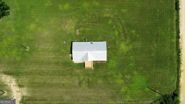 an aerial view of a house with a yard table and chairs