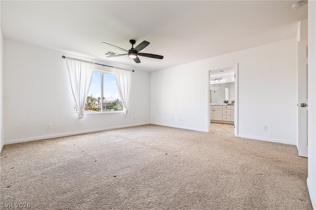 5510 Ripple Ridge Avenue Las Vegas, NV 89139 - Photo 28 of 45 This expansive bedroom offers comfortable carpeting and a bright window with a view.