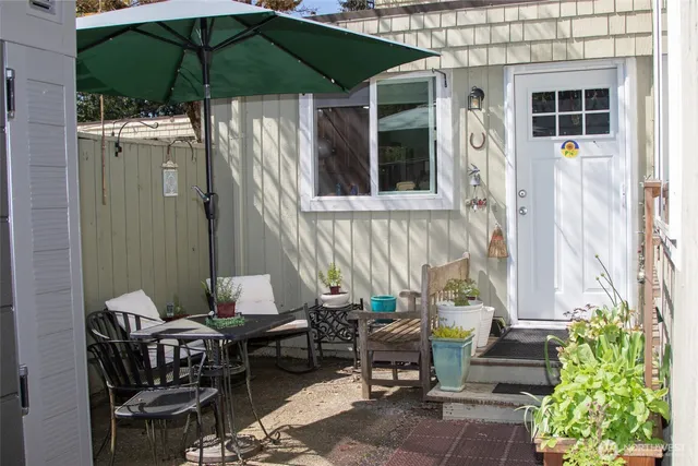 a patio with table and chairs under an umbrella