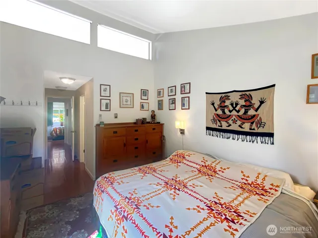 a bedroom with a bed and a painting on the wall